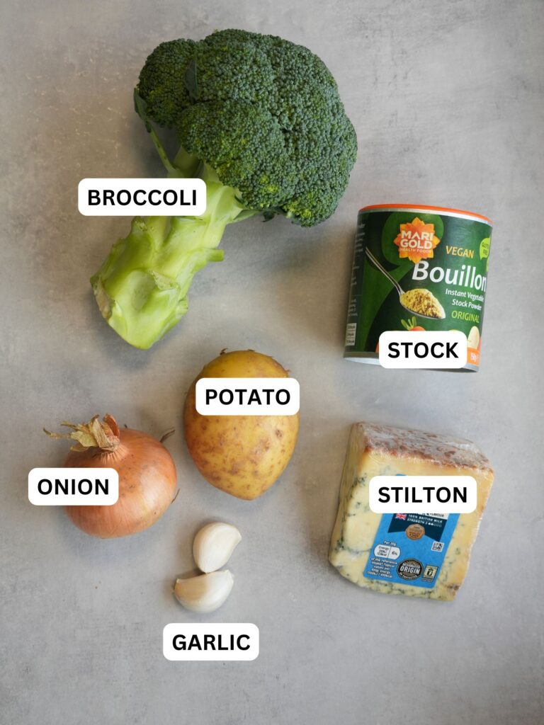 ingredients for broccoli and stilton soup laid out and labelled: broccoli, stock, potato, onion, garlic, stilton