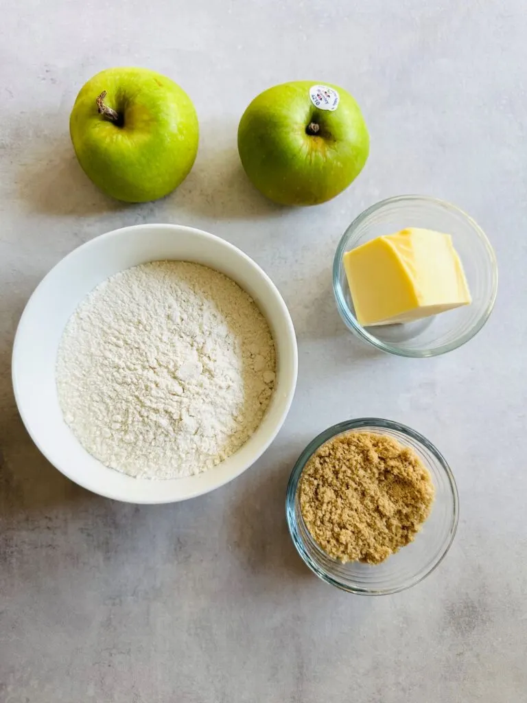 two bramley apples, flour, butter, sugar in pots ready to make an air fryer apple crumble 