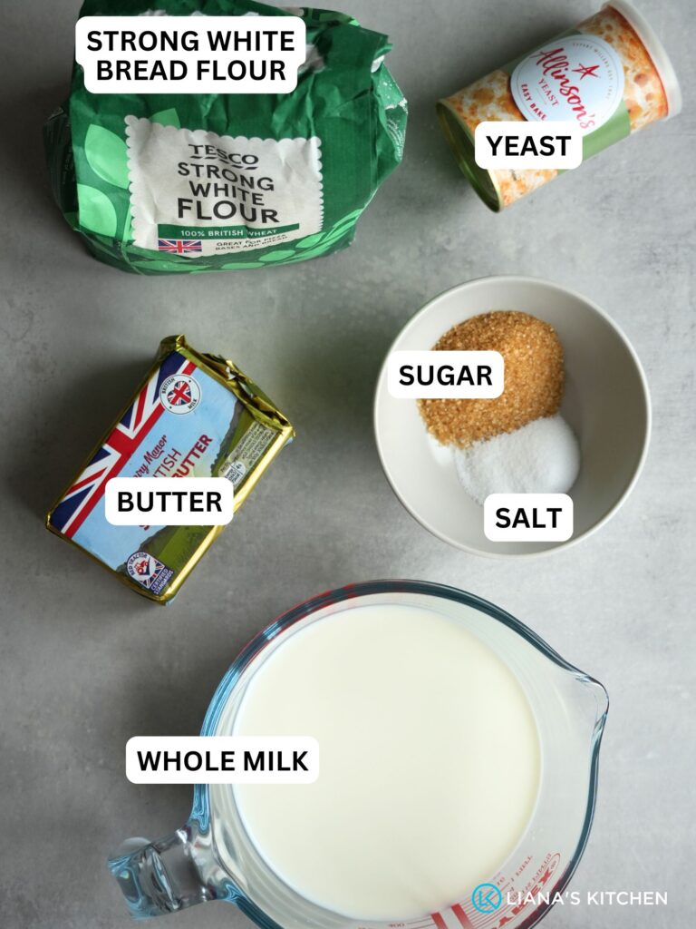 ingredients laid out and labelled for milk bread in bread maker: strong white bread flour, yeast, butter, sugar, salt and whole milk