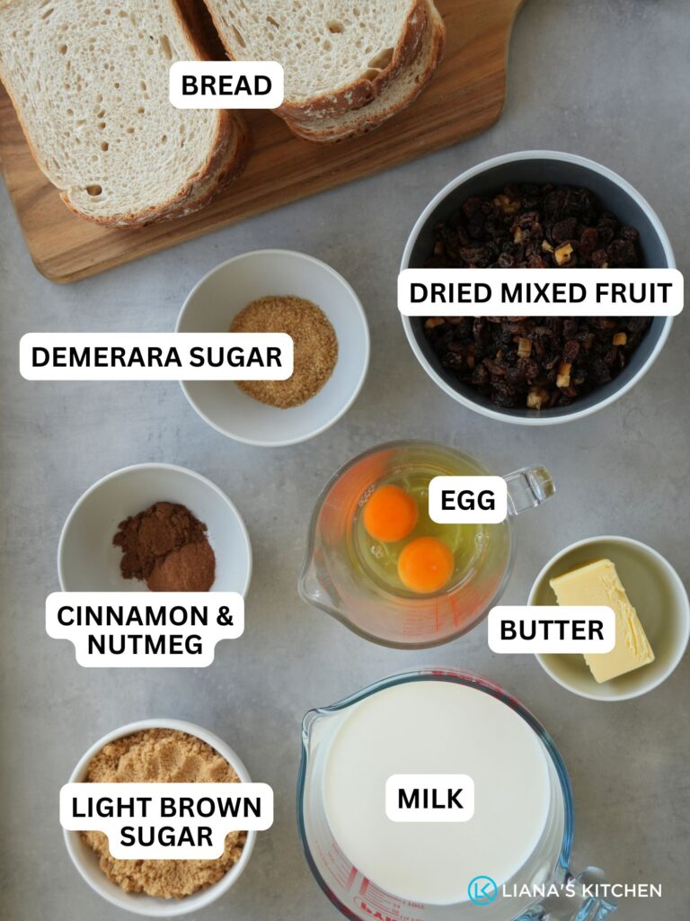 ingredients laid out and labelled for bread pudding: bread, demerara sugar, dried mixed fruit, cinnamon and nutmeg, egg, butter, light brown sugar and milk