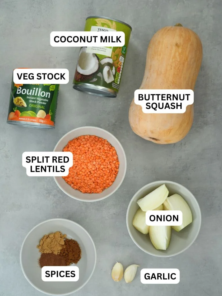 ingredients laid out and labelled for butternut squash and split red lentil soup: vegetable stock, coconut milk, butternut squash, split red lentils, spices, onion, garlic