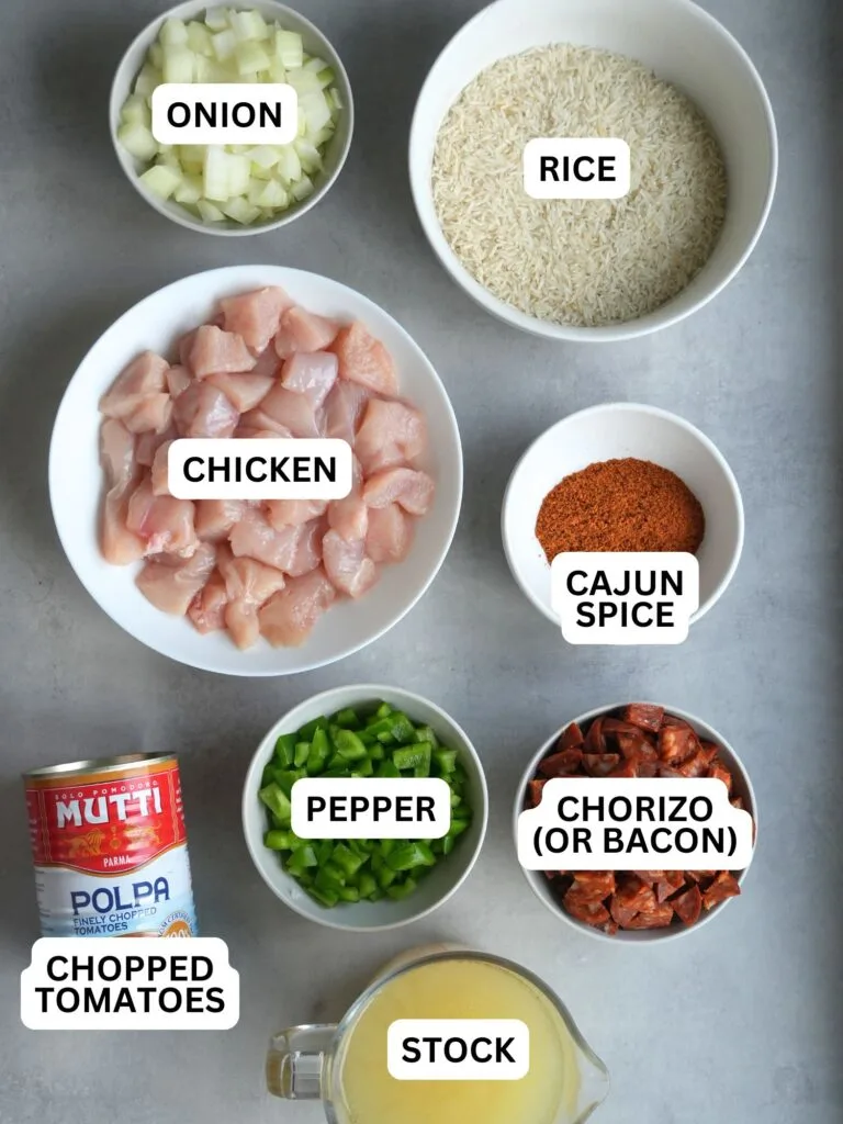 ingredients laid out and labelled: onion, rice, chicken, cajun spice, chopped tomatoes, pepper, chorizo (or bacon), stock
