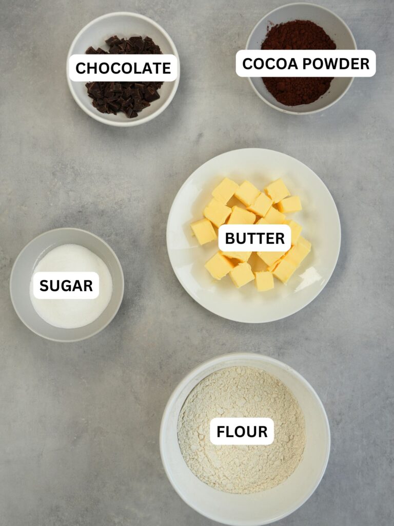 ingredients laid out for chocolate shortbread, labelled: chocolate, cocoa powder, butter, sugar, flour