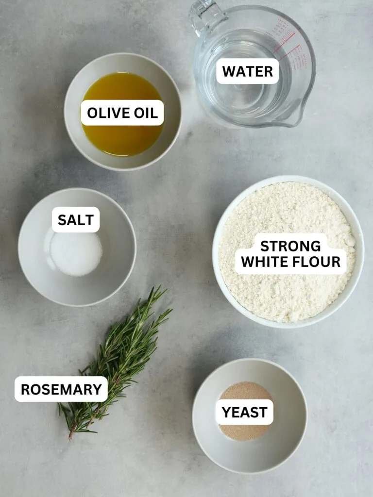ingredients laid out and labelled for focaccia: olive oil, water, salt, strong white flour, rosemary and yeast