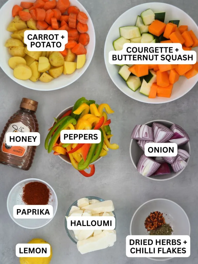 ingredients laid out and labelled for air fryer halloumi and roasted vegetables: carrot and potato, courgette and butternut squash, honey, peppers, onion, paprika, halloumi, lemon, dried herbs and chilli flakes