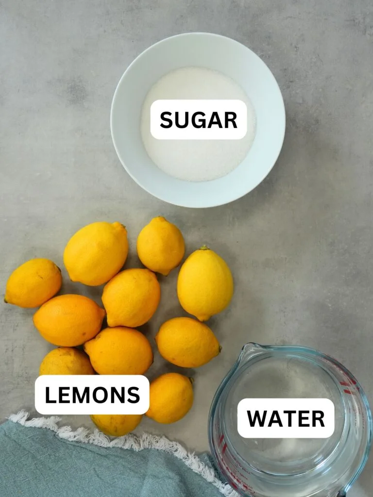 ingredients laid out for homemade lemonade, sugar, lemons and water