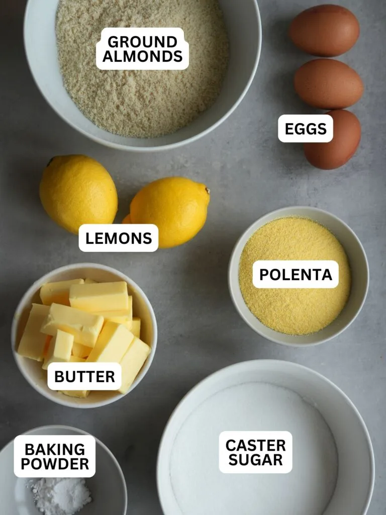ingredients laid out and labelled for lemon polenta: polenta, eggs, lemons, ground almonds, butter, baking powder, caster sugar