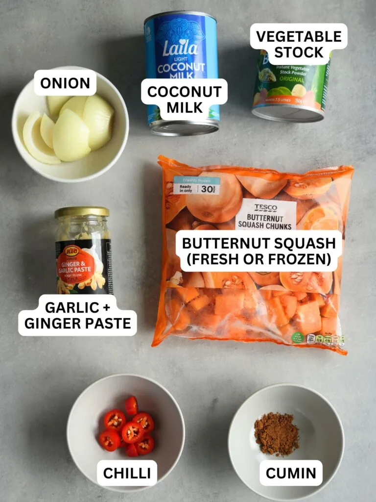 ingredients laid out and labelled for coconut. chilli and butternut squash soup in a soup maker: onion, coconut milk, vegetable stock, garlic and ginger paste, butternut squash (fresh or frozen), chilli and cumin