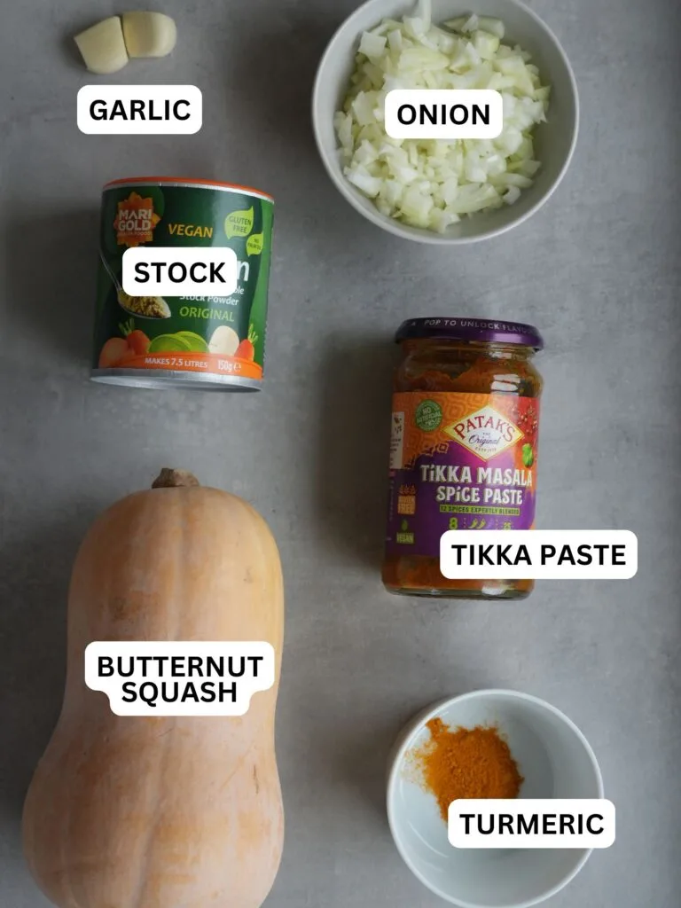 ingredients laid out and labelled for soup: 2 cloves garlic, onion, stock, tikka paste, butternut squash and turmeric