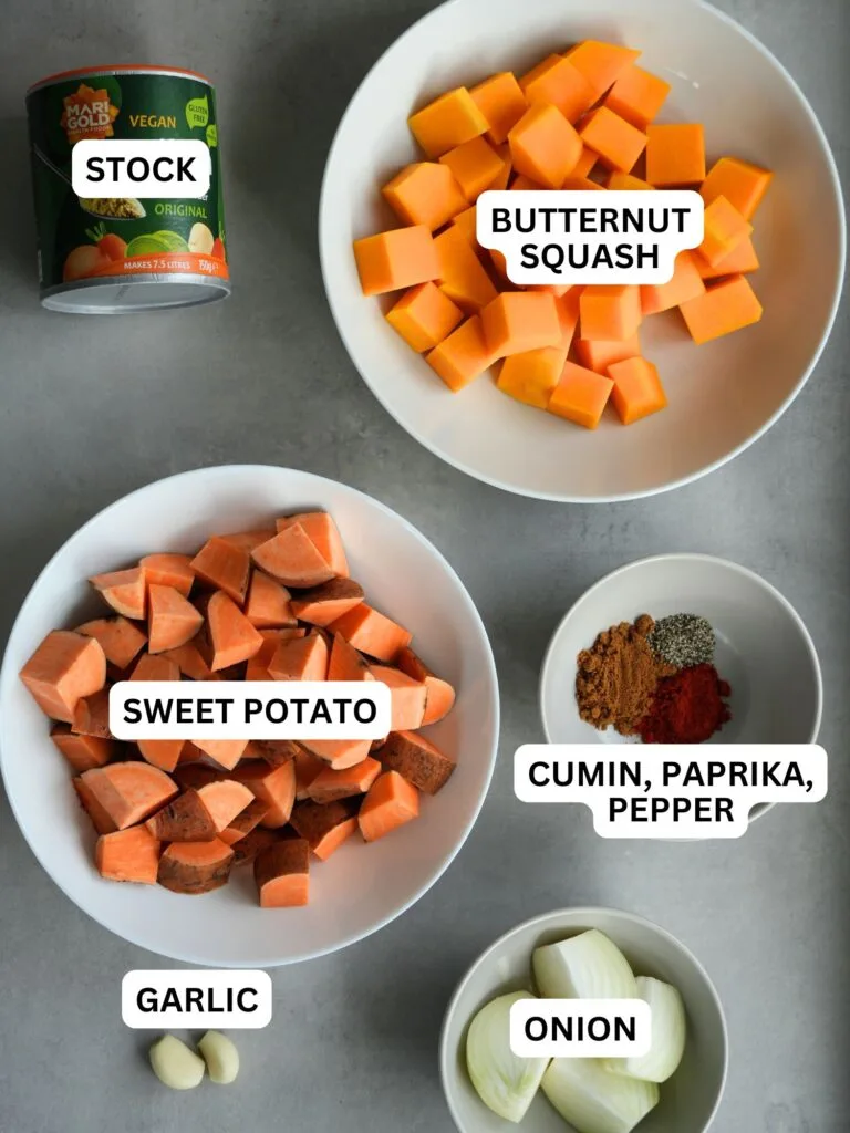 ingredients laid out and labelled for sweet potato and butternut squash soup: stock, butternut squash, sweet potato, cumin, paprika, pepper, garlic, onion