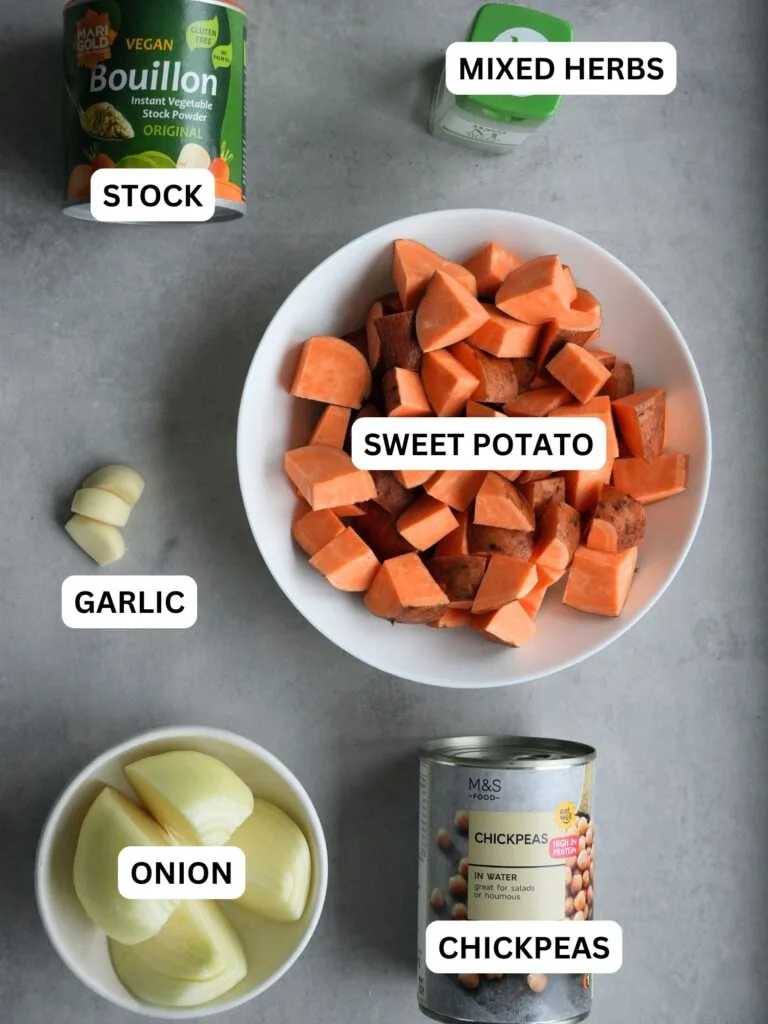 ingredients laid out and labelled for sweet potato and chickpea soup: stock, mixed herbs, garlic, sweet potato, onion, tin of chickpeas