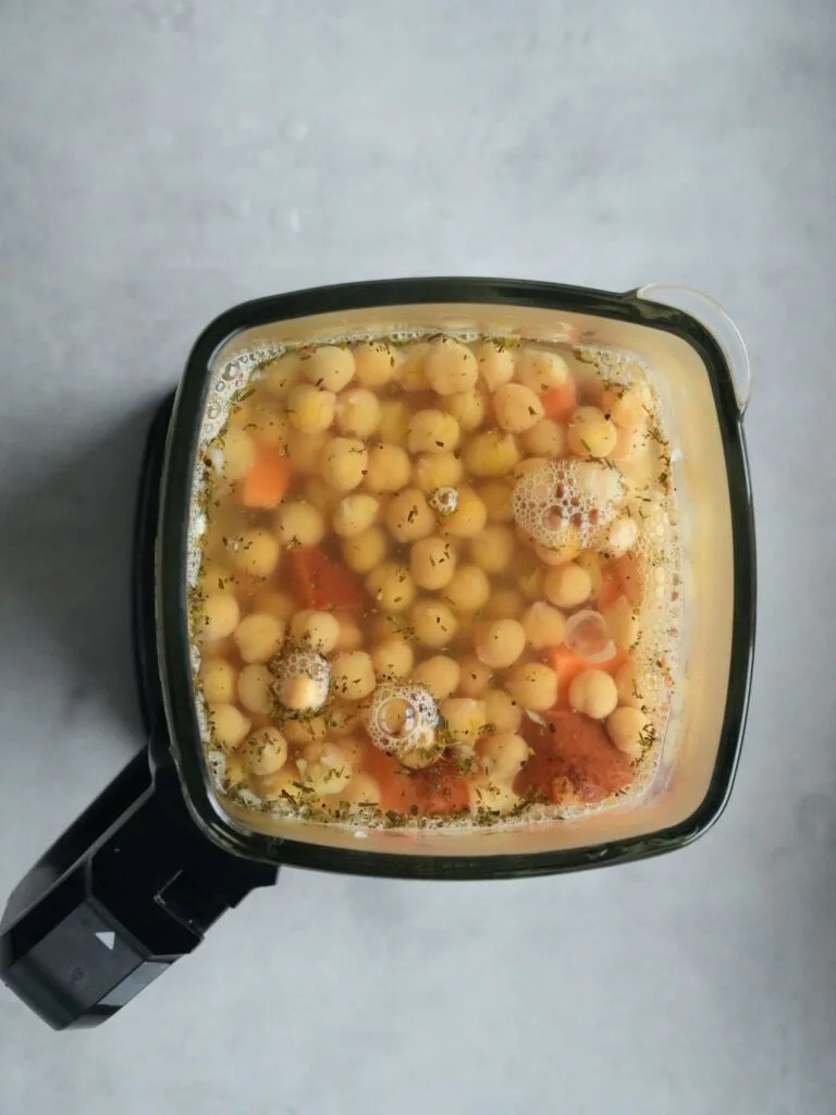 ninja soup maker jug with view from the top down filled with chickpeas, water, sweet potatoes, dried mixed herbs