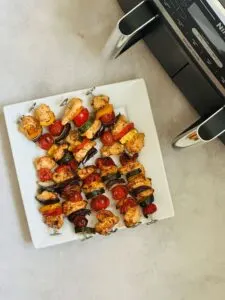 kebabs on plate next to Ninja Dual Air Fryer