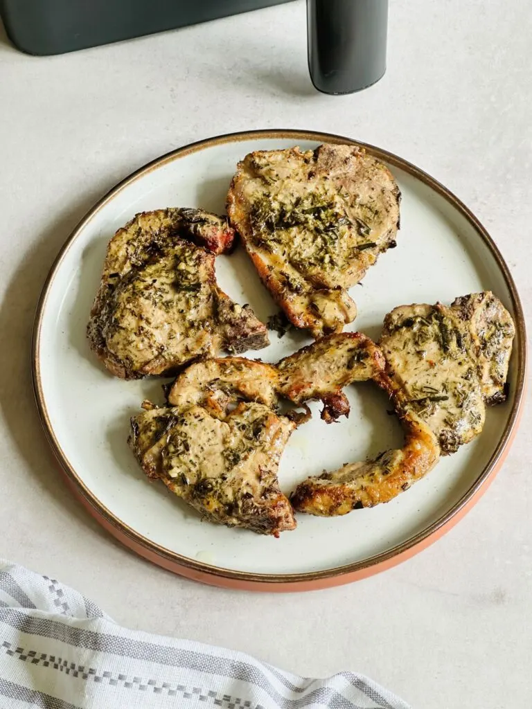air fried lamb chops on a plate next to an air fryer