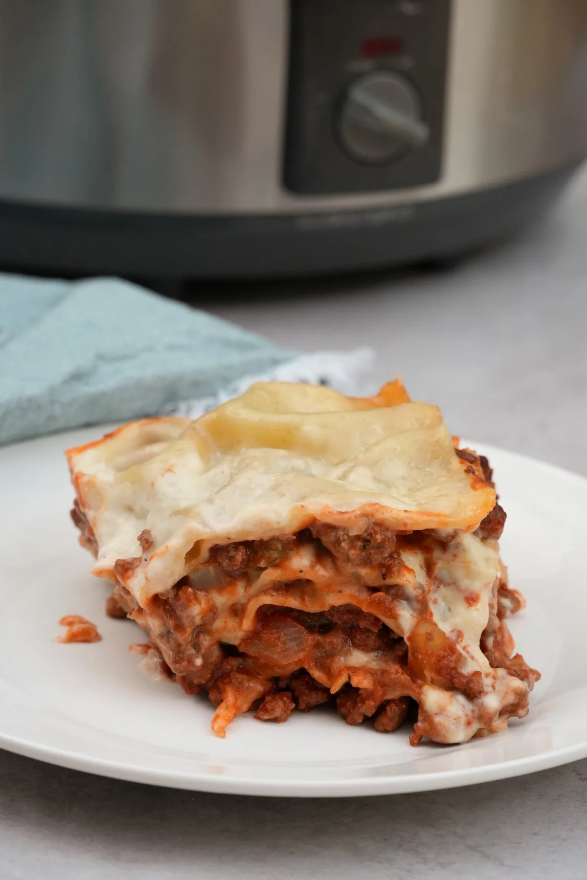 lasagne on plate next to slow cooker