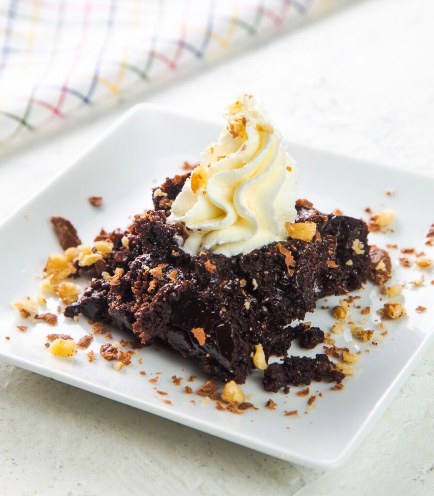 slow cooker chocolate lava cake on a plate with cream