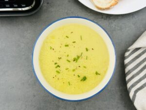 leek and potato soup in a bowl with chives on next to a Ninja soup maker