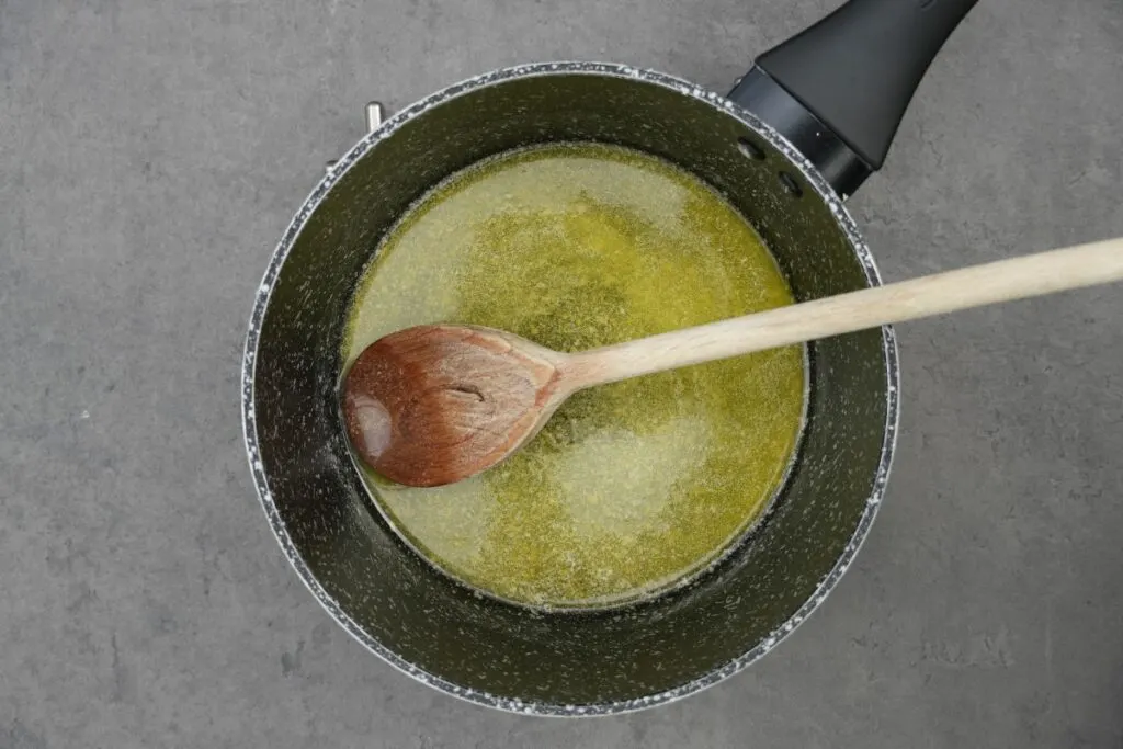 melting butter in saucepan with wooden spoon