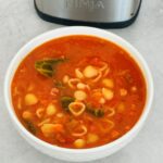 minestrone soup in a bowl next to a Ninja Soup Maker