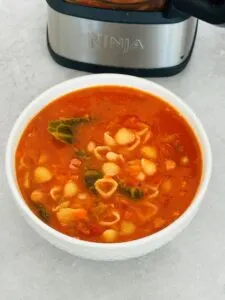 minestrone soup in a bowl next to a Ninja Soup Maker