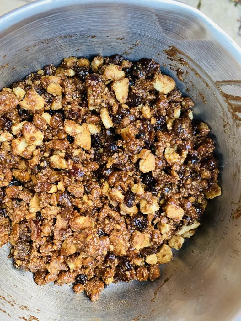 crushed biscuits, raisins, chopped cherries, melted butter, golden syrup and cocoa powder mixed together in a bowl.