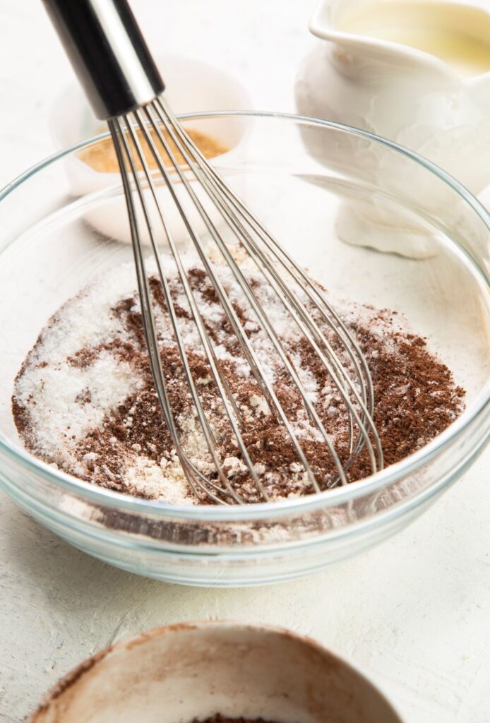 whisking dry ingredients together in a bowl for slow cooker chocolate lava cake