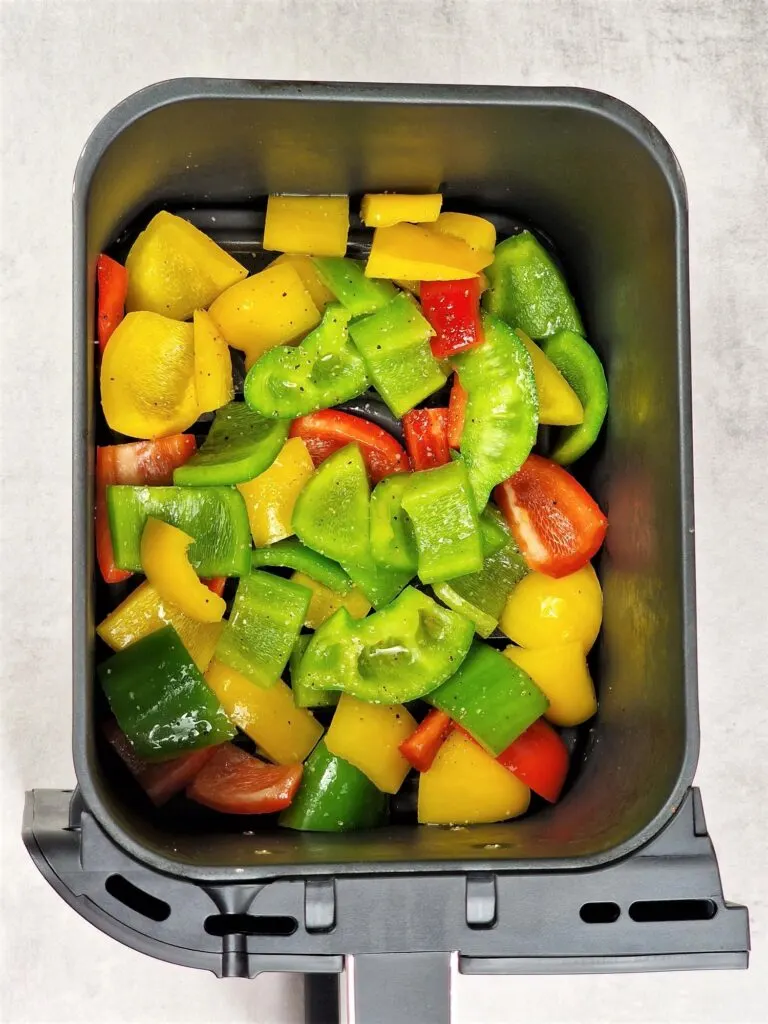 oiled and seasoned peppers in air fryer basket