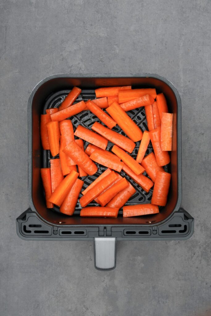 chopped carrots in air fryer basket ready for roasting