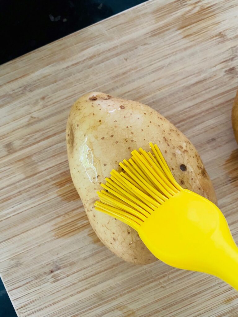 oiling a baking potato before adding it to an air fryer