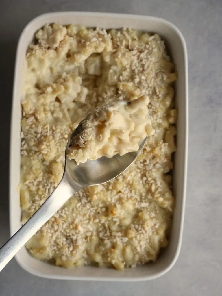 macaroni cheese in an oven dish with a silver serving spoon 