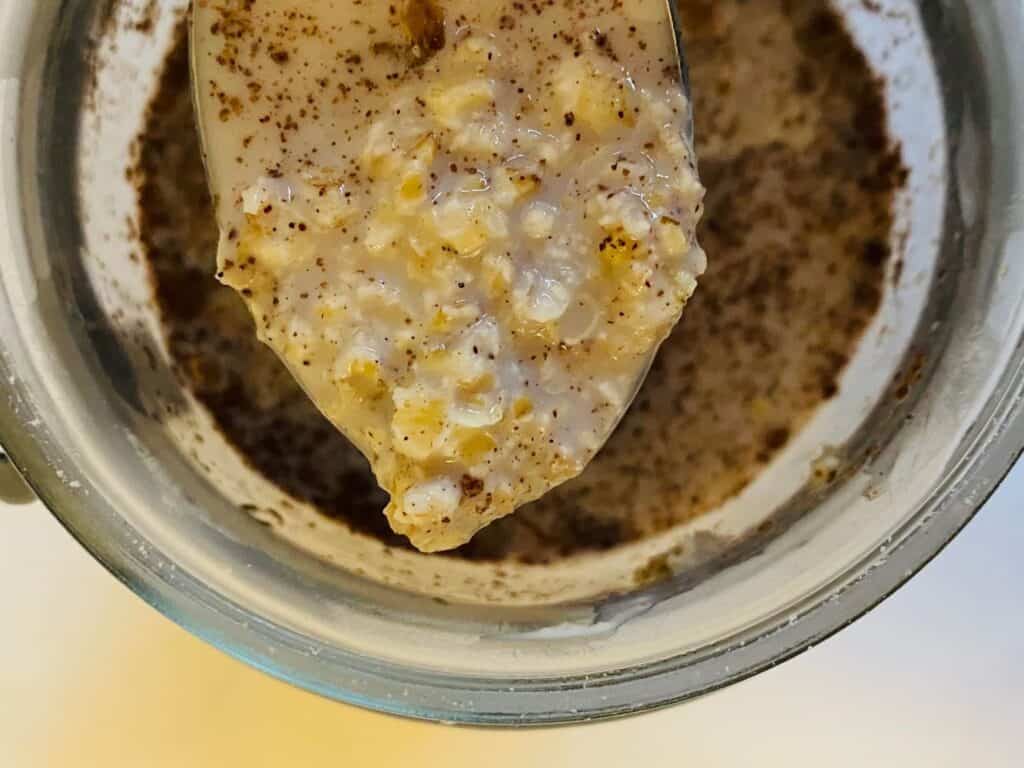 overnight oats on a spoon above mason jar