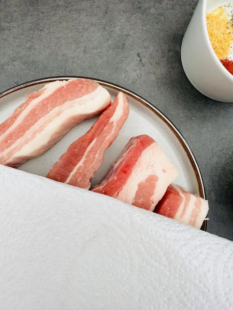 pat pork belly slices dry with kitchen paper
