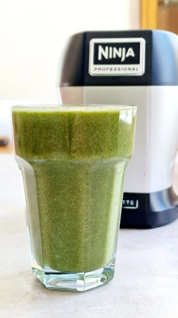 pineapple cucumber avocado grreen smoothie in front of Nutri Ninja blender