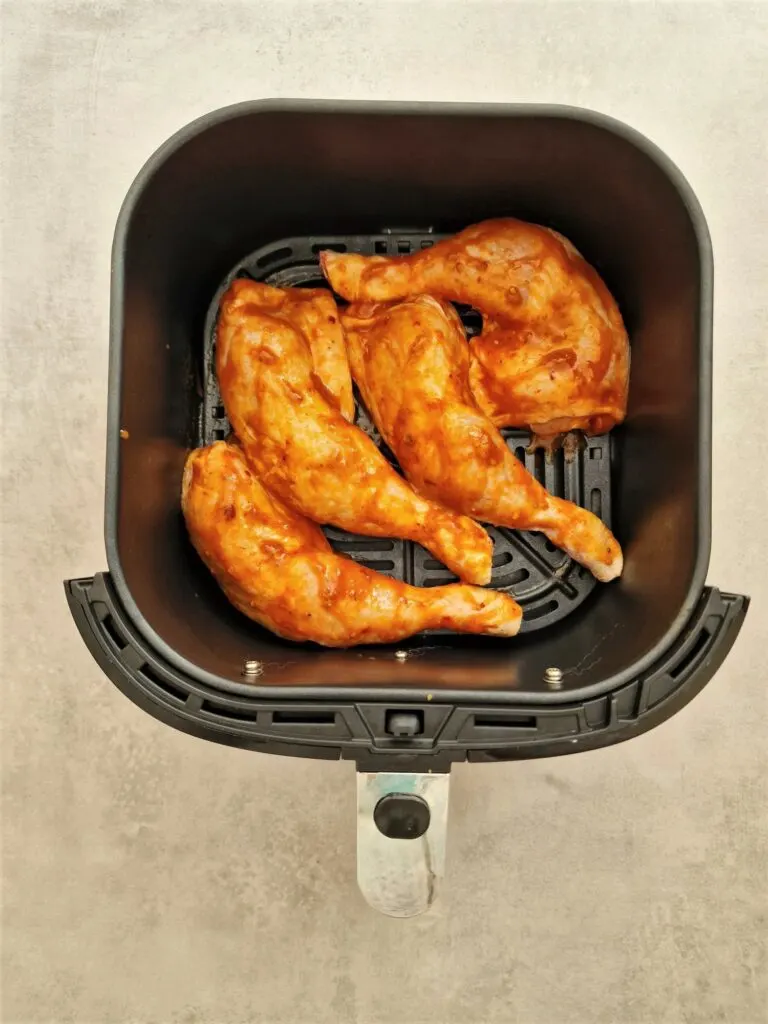 marinated chicken legs in an air fryer basket