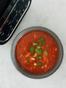 piri piri chicken soup in a bowl next to a Ninja soup maker