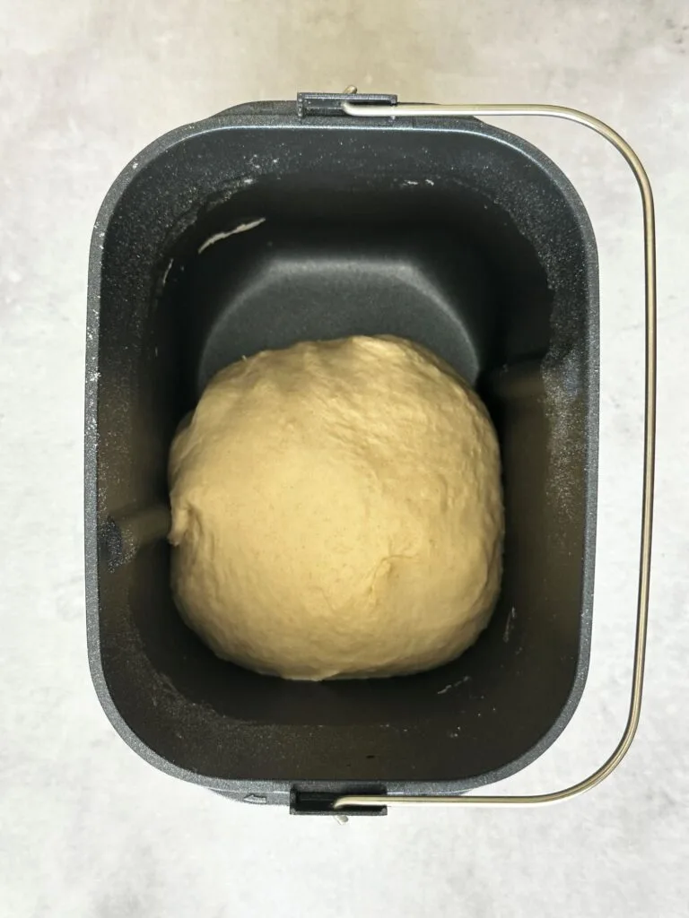 pizza dough in a ball in bread maker tin