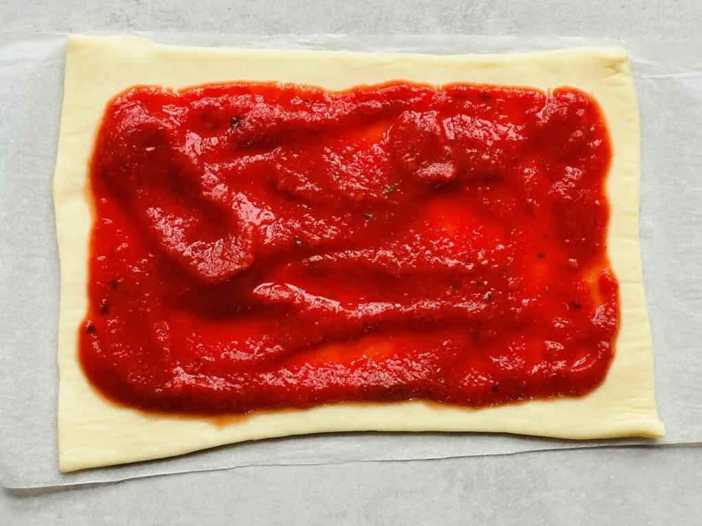 pizza dough with pizza sauce
