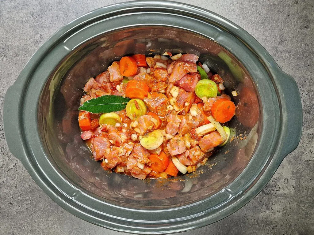 pork casserole ingredients mixed in a slow cooker
