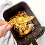 crispy air fryer peel above air fryer basket