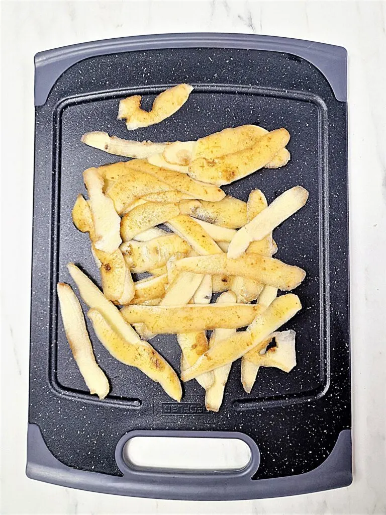 potato peelings on chopping board