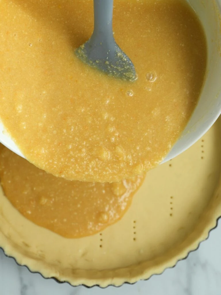 pouring filling for treacle tart into pastry case