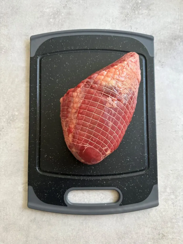 raw beef joint on chopping board