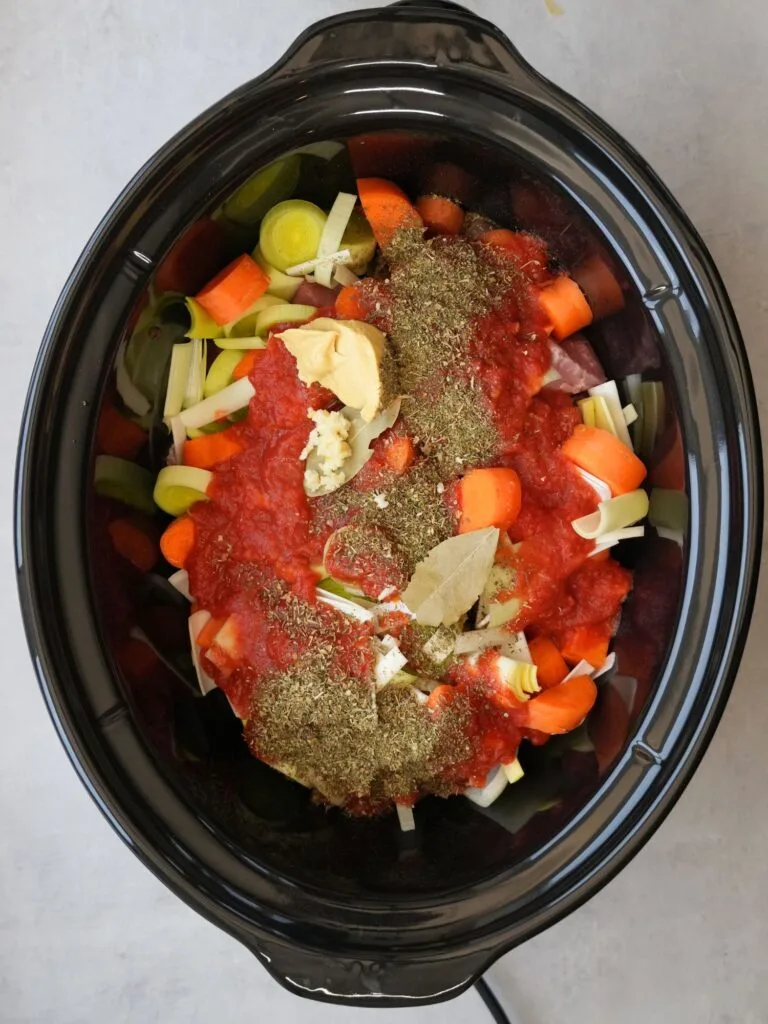 slow cooker filled with raw ingredients for cooking a slow cooker