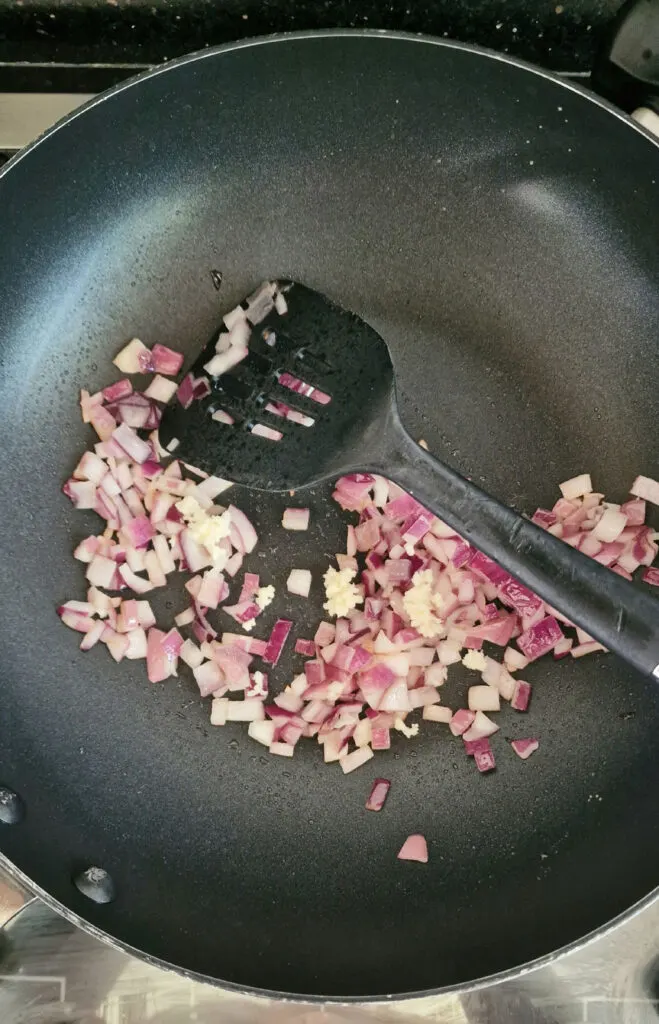 frying red onions in pan