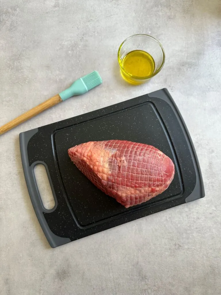 raw roast beef with oil and brush
