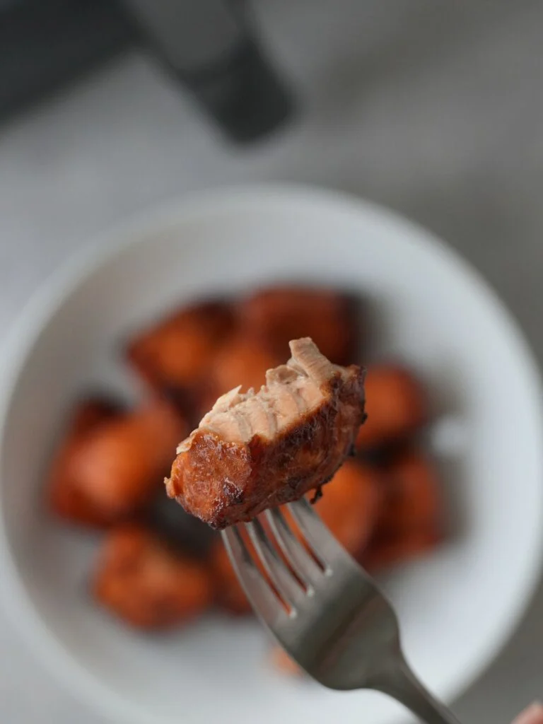 salmon bite on a fork shown from the inside