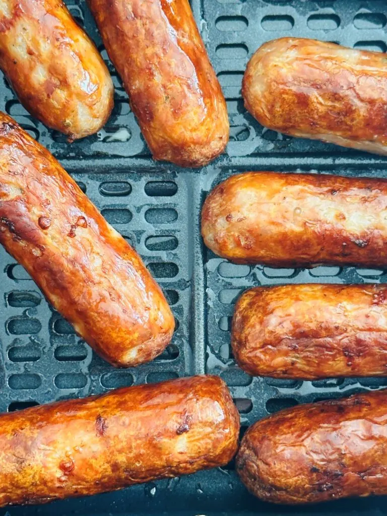 browned sausages in air fryer basket