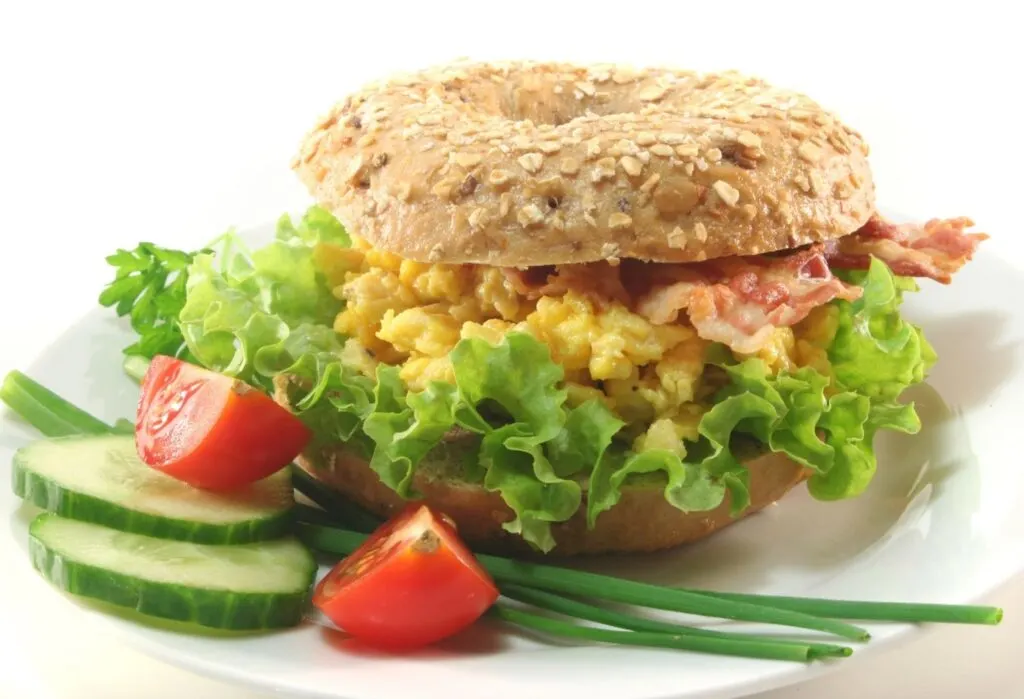 bagel with scrambled egg bacon and salad