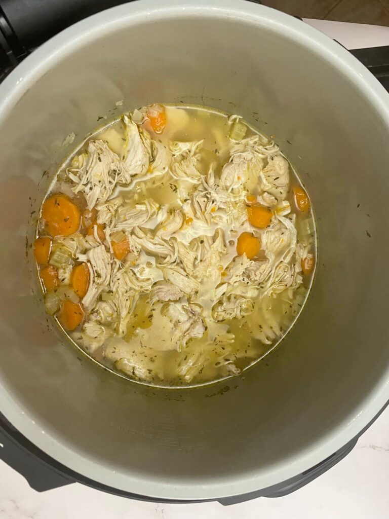 shredded chicken with carrots and stock in Ninja Foodi for stew.