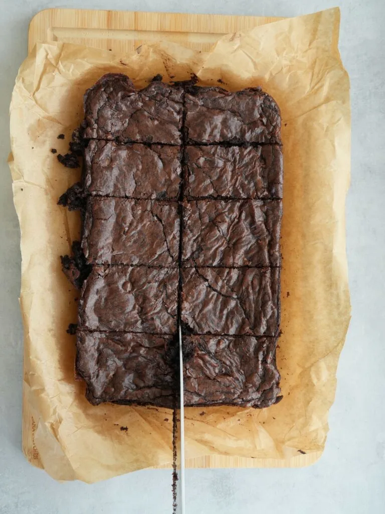 brownies sliced with a knife sitting on top of some baking paper